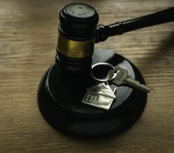 Il simbolo del pignoramento immobiliare: martello giudiziario e chiave di casa