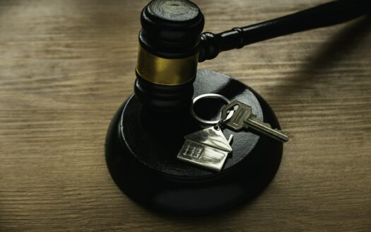 Il simbolo del pignoramento immobiliare: martello giudiziario e chiave di casa
