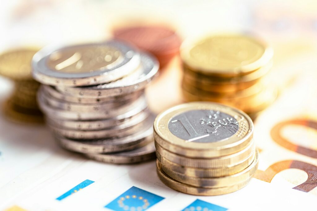Documento di comodato d'uso gratuito, sotto alcune pile di euro in monete, rappresentando un concetto di risparmio fiscale sull'IMU.
