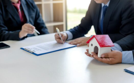 Firma di un contratto di locazione con canone concordato, con un modello di casa in mano